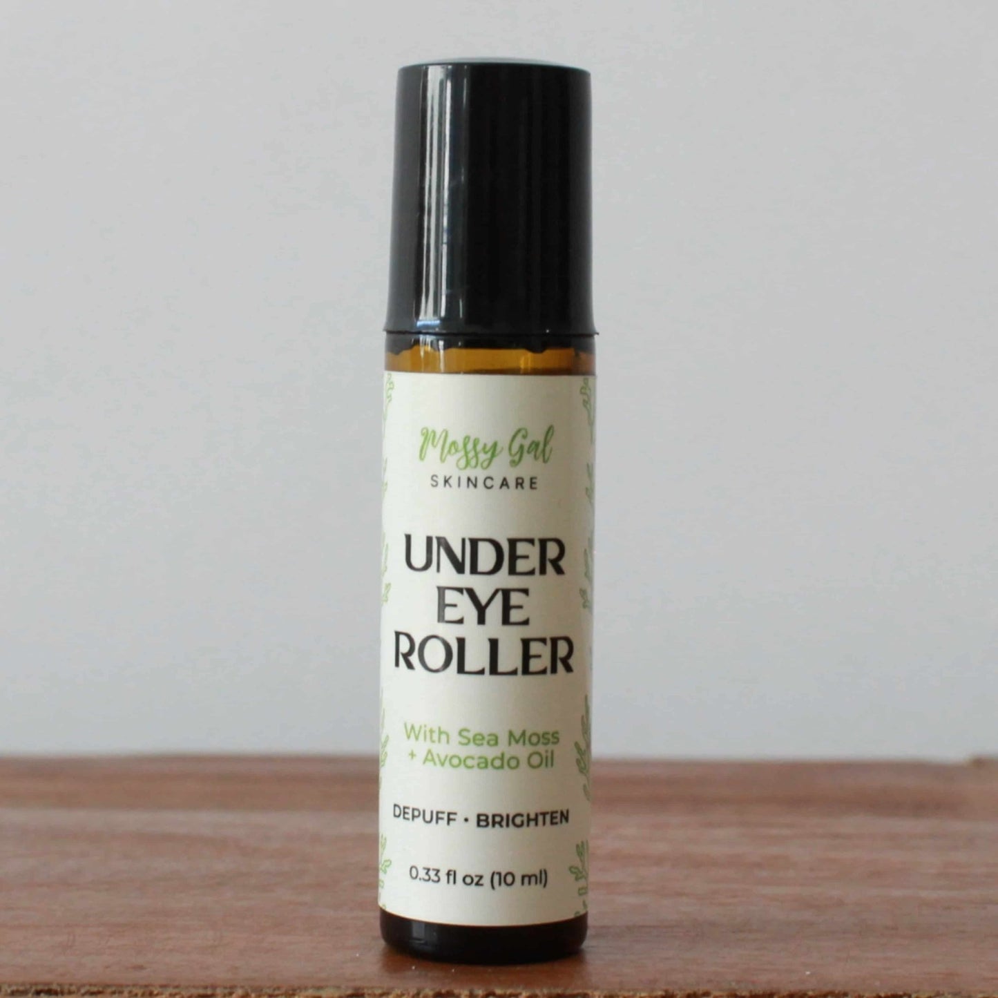 Under eye roller bottle with label on a wooden surface